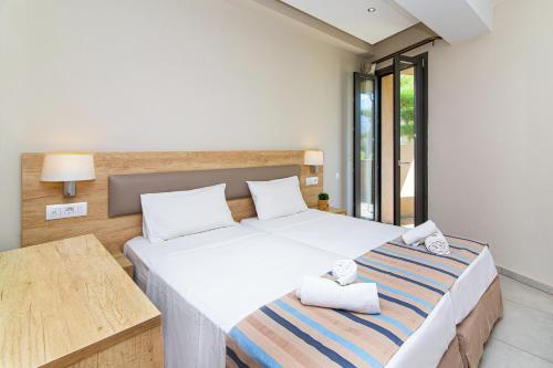 a bedroom with a large bed with towels on it at Theo Star Beach Hotel in Malia