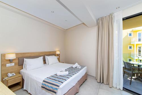 a hotel room with a bed and a balcony at Theo Star Beach Hotel in Malia