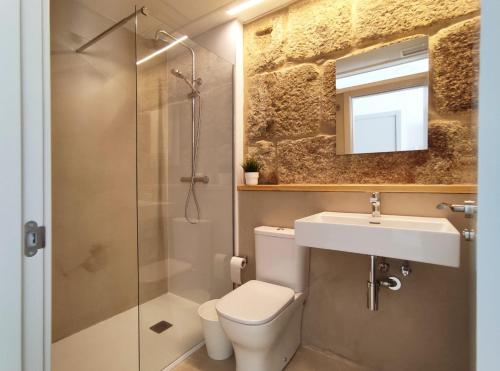 a bathroom with a toilet and a sink and a shower at Cánovas 21 in Carballino
