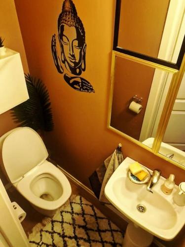 a bathroom with a toilet and a sink and a mirror at Sjarmerende leilighet i hjerte av Tønsberg by in Tønsberg