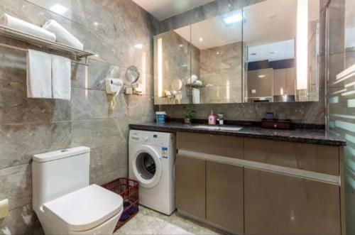ein Badezimmer mit einem WC, einem Waschbecken und einer Waschmaschine in der Unterkunft Yoyo Apartment Jiedeng Metropolis Branch, Beijing Road in Guangzhou