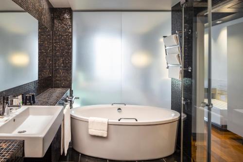a bathroom with a tub and a sink at Swissotel Tallinn in Tallinn