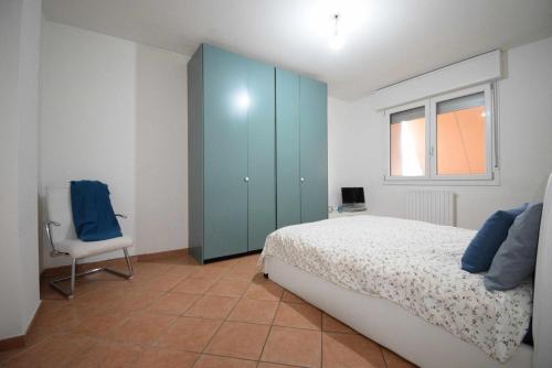 a bedroom with a bed and a blue cabinet and a chair at La Casa Gandolfi in Castello dʼArgile