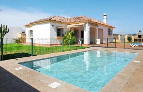 a swimming pool in front of a house at CHALET ROBLES in Cádiz
