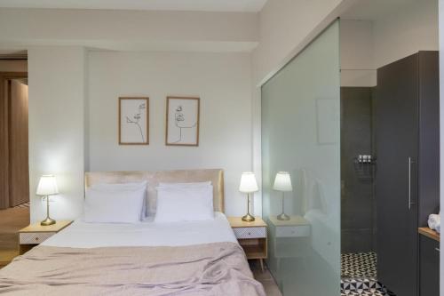 a bedroom with a large bed and two lamps at Canyon 2 villa with private pool in Rethymno Town