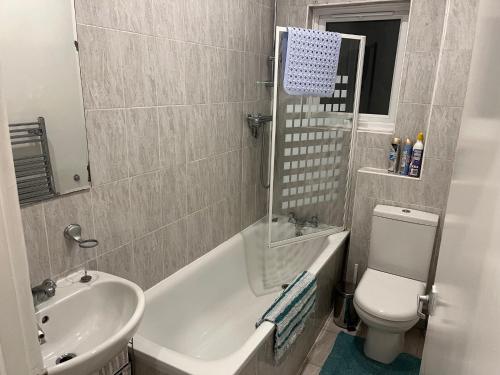 een badkamer met een wastafel, een bad en een toilet bij Lovely 1 bedroom flat in quiet Wimbledon in Londen