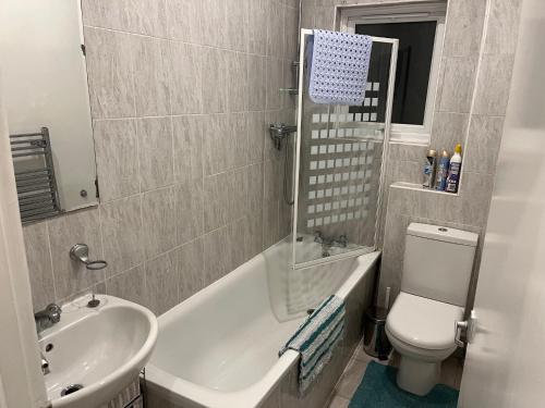a bathroom with a sink and a tub and a toilet at Lovely 1 bedroom flat in quiet Wimbledon in London