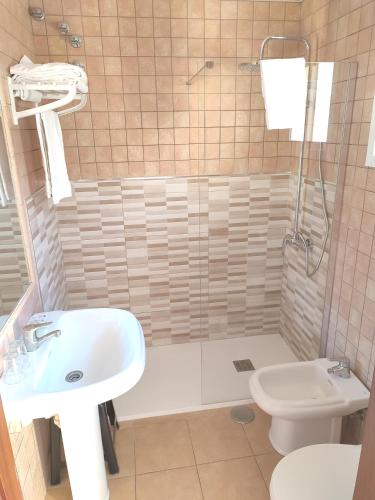 a bathroom with a sink and a toilet and a shower at Hostal Alhaja Playa in El Puerto de Santa María