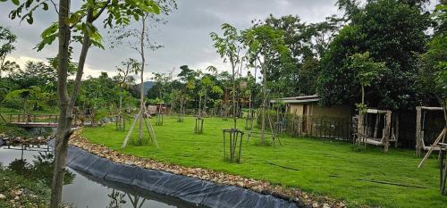 a park with a playground with trees and water at Teak@Teak in Ban Cha-om