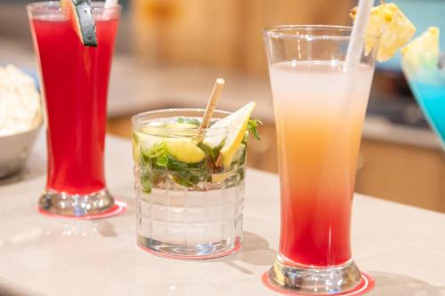 three cocktails sitting on a table at Ramada by Wyndham Kasauli in Kasauli