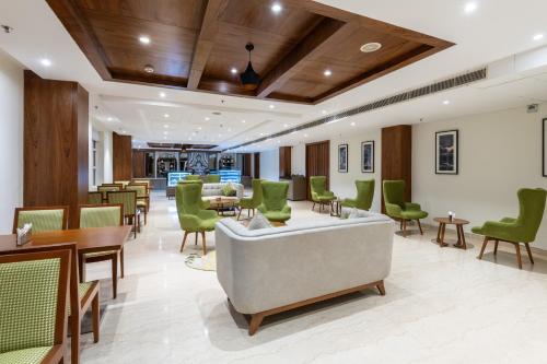 a waiting room with green chairs and tables at Ramada by Wyndham Kasauli in Kasauli