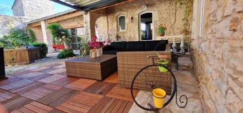 a patio with a couch and a table at Demeure de la Baronne in Vézénobres