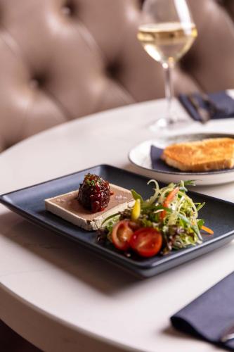 a plate of food on a table with a glass of wine at The Kylestrome in Ayr