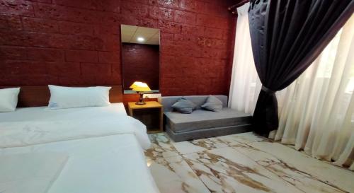 a hotel room with two beds and a couch at West Coast Gokarna in Gokarna