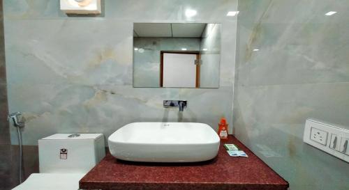 a bathroom with a white sink and a mirror at West Coast Gokarna in Gokarna