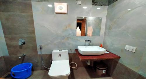 a bathroom with a sink and a toilet and a mirror at West Coast Gokarna in Gokarna
