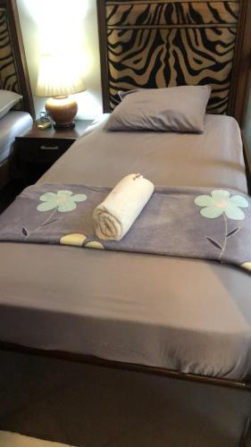 a bed with a blanket with flowers on it at 2 separate fully furnished condo units 1BR on the 23rd flr and 3BR penthouse on the 41st flr, with different bookings and daily rates in Ermita, Manila near SLEC,US Embassy, Mall and Parks in Manila