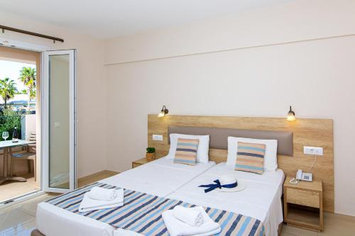 a bedroom with a large bed with a blue and white striped blanket at Theo Star Beach Hotel in Malia