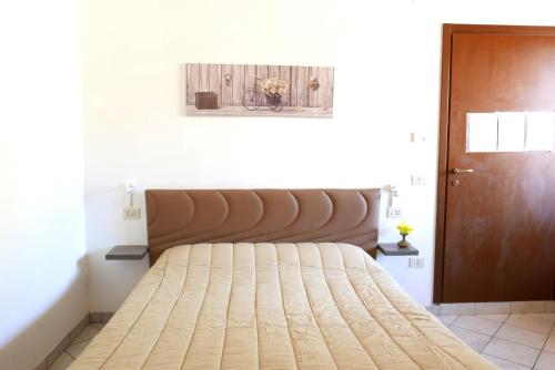1 cama en un dormitorio con cabecero de madera en B&B Severini, en Morrovalle
