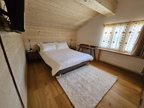 a small bedroom with a bed and a window at Chalet Familial Sublime in Crans-Montana