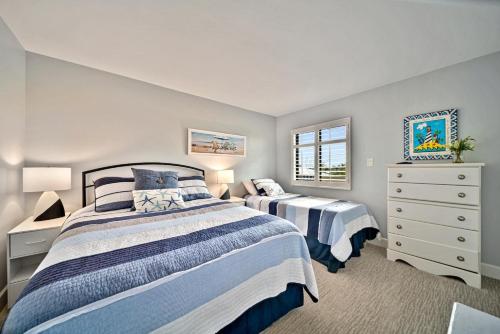 a bedroom with two beds and a dresser at Loggerhead Cay #324 in Sanibel