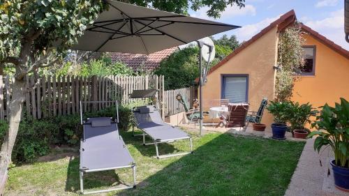 a patio with two chairs and an umbrella at Ferienwohnung Kollmer in Ebern