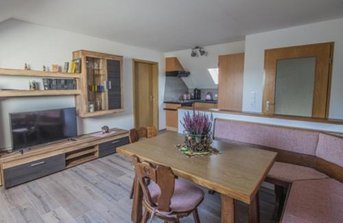 a kitchen with a wooden table and a dining room at Ferienwohnung Kollmer in Ebern