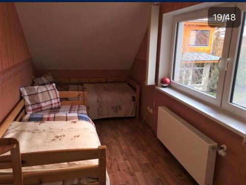 een kleine kamer met 2 bedden en een raam bij Dimanti in Ragaciems