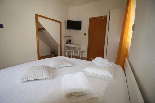 a bedroom with a white bed with towels on it at Room Šolo in Sumartin