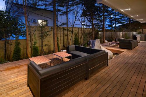 a patio with a couch and a table on a deck at Azumakan in Nihommatsu