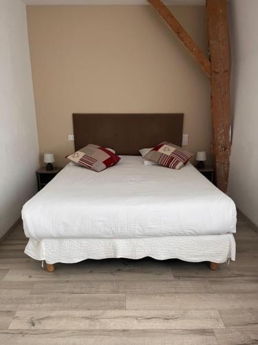 a bedroom with a large white bed with two pillows at Chambres d'Hotes Noir Lion in Péronne