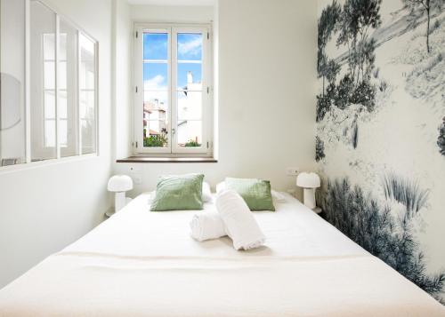 uma cama branca num quarto branco com uma janela em Bel appartement, offrant calme et luminosité, proche Côte des Basques em Biarritz