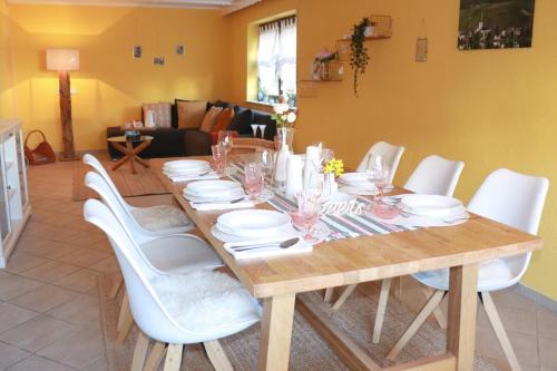 stół jadalny z białymi krzesłami wokół niego w obiekcie Ferienhaus Mosel Cottage in Piesport w mieście Piesport
