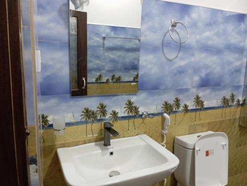 łazienka z umywalką i zdjęciem plaży w obiekcie Forest Paddy Homestay w mieście Ella