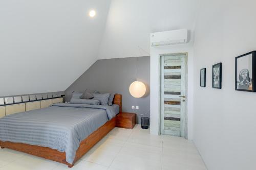 a bedroom with a bed in a white room at Beautiful Penthouse w/ incredible views, pool, & cinema room! in Canggu