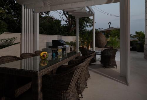 a patio with a table and chairs on a porch at Jakuzzi Vila Suartini Orebić in Orebić