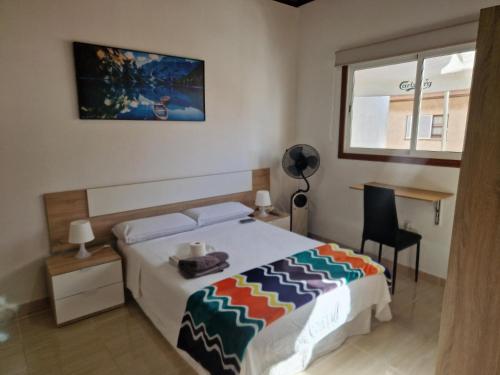 a bedroom with a bed and a desk and a window at Habitación matrimonial privada con areas compartidas in Las Lagunas