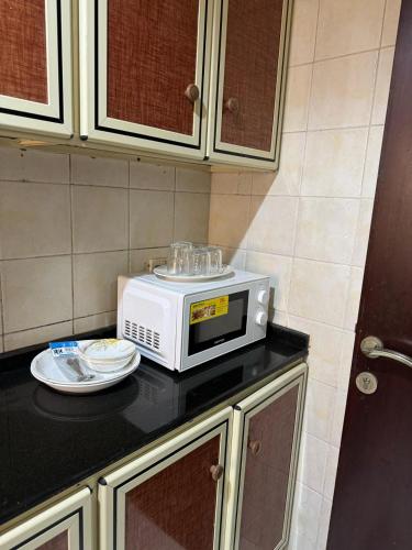 a microwave sitting on top of a counter in a kitchen at Fully Furnished Studio Appartment next to Sharaf DG metro Station in Dubai