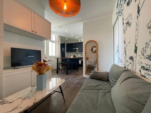 een woonkamer met een bank en een tafel bij Élégant et lumineux appartement à proximité de tous les lieux d'intérêt in Biarritz