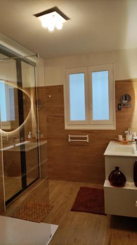 une salle de bain avec une douche en verre et un lavabo dans l'établissement La Chênaie, à Montauban