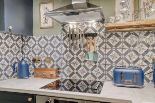 a kitchen with a counter with a patterned wall at The Darwin Malvern Suite in Great Malvern