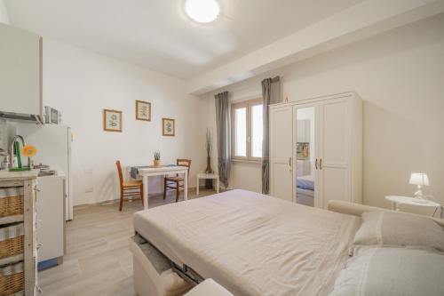 - une chambre blanche avec un lit et une table dans l'établissement A Casa di Coco - Goelba, à Portoferraio