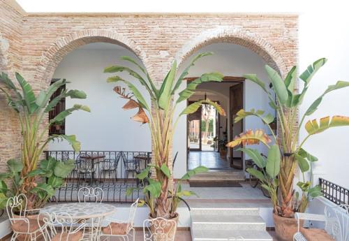 Zimmer mit zwei Torbögen mit Pflanzen und einem Tisch in der Unterkunft Hotel 3* La Casona de las Flores in Ondara