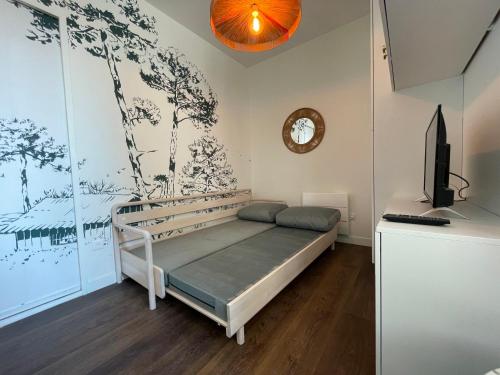een slaapkamer met een bed en een tv. bij Élégant et lumineux appartement à proximité de tous les lieux d'intérêt in Biarritz