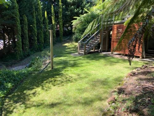 a yard with a house and a building with trees at Cockatoo Rainforest Escape in Cockatoo