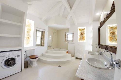 a bathroom with a sink and a washing machine at Villa Archontiko in Makris Gialos