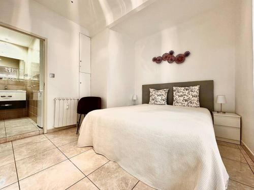 une chambre avec un grand lit blanc et une salle de bain dans l'établissement Cannes appartement 1 chambre - 13P, à Cannes