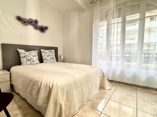 une chambre avec un grand lit et une fenêtre dans l'établissement Cannes appartement 1 chambre - 13P, à Cannes