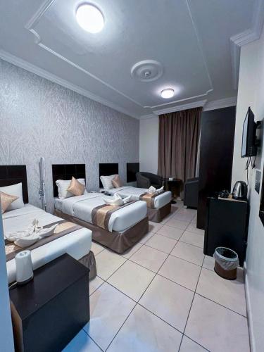 a hotel room with two beds and a couch at كنوز العمر in Mecca