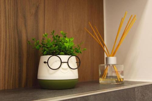 a green and white vase with glasses sitting on a shelf at 6 DOC Dream Apartment 6 +Parcare in Oradea